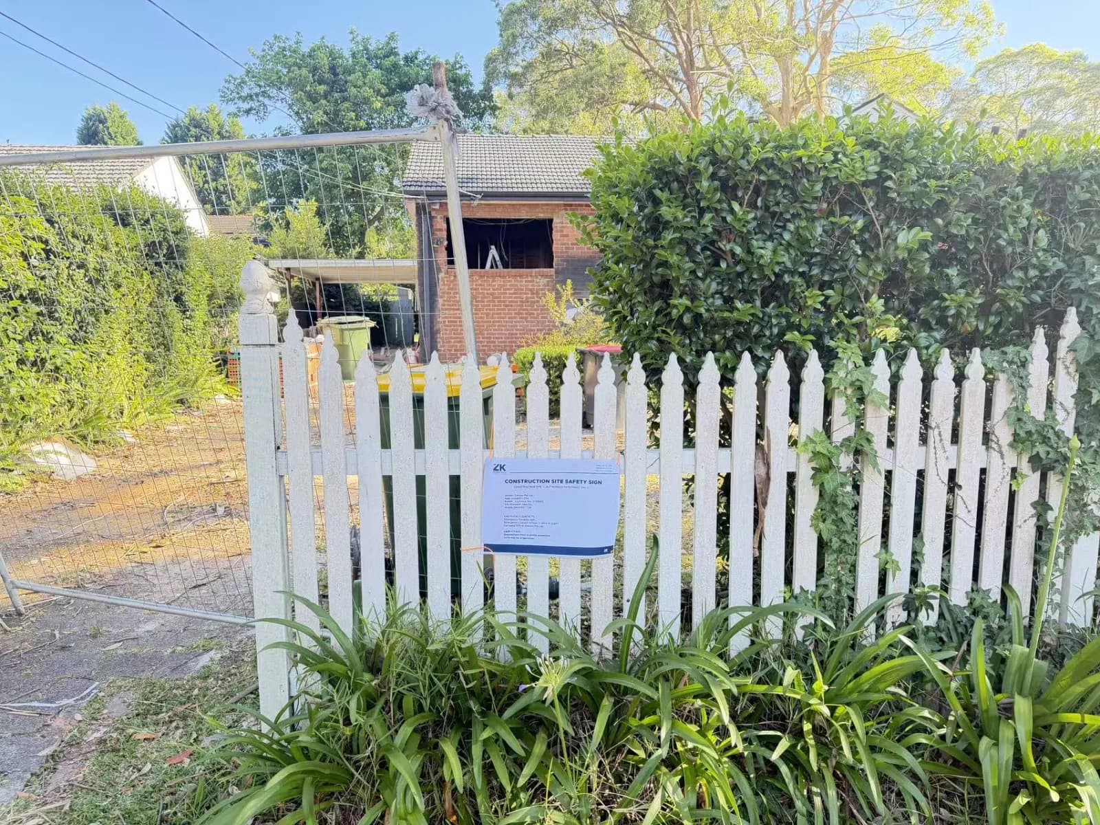 Turramurra renovation site seen from the front garden, with temporary fencing and a construction safety sign
