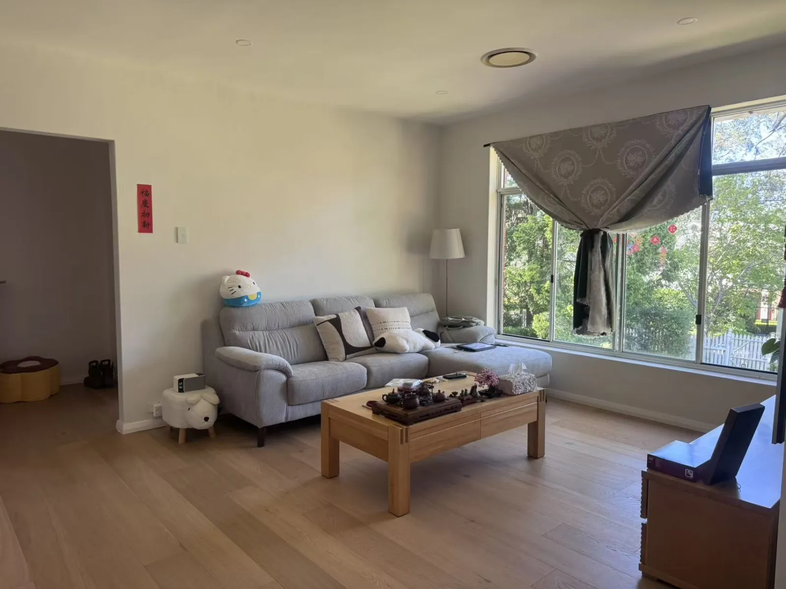 Completed Turramurra living room with timber flooring, painted walls and a large window