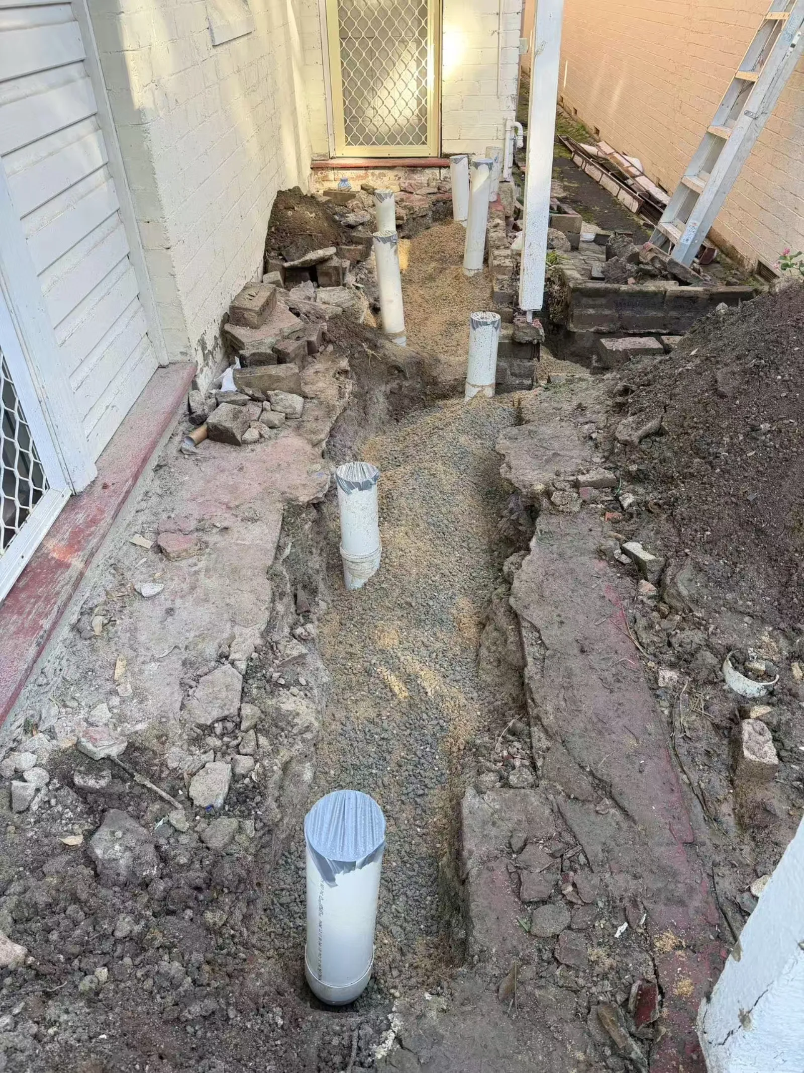 Drainage pipework and excavation beside a house during the Chatswood renovation
